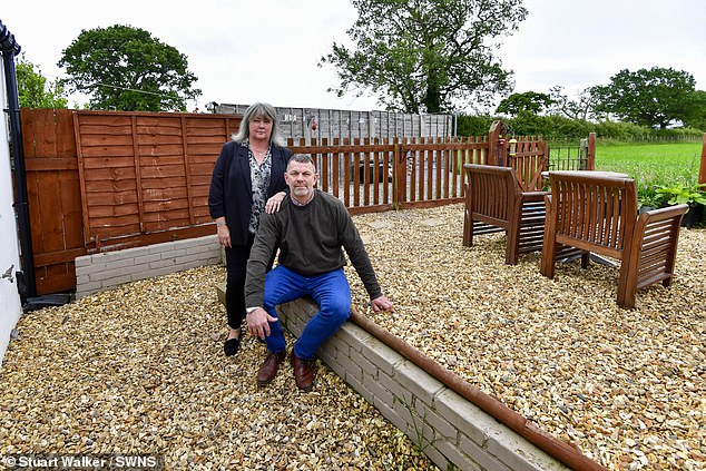 Devastated: David and Rebecca French next to the wall which marks the boundary between their five foot garden and the rest of the land owned by an adjacent farm