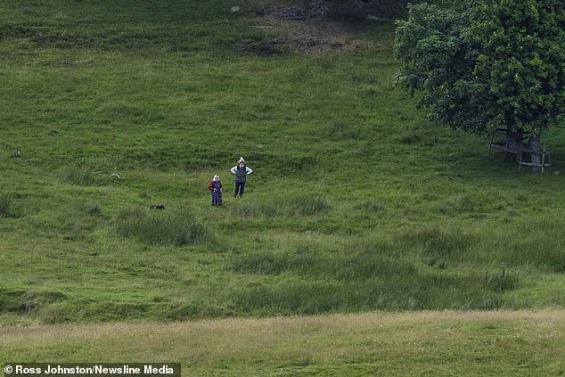 The Queen (pictured) is seen walking her Dorgis on Balmoral Estate at Glen Muick