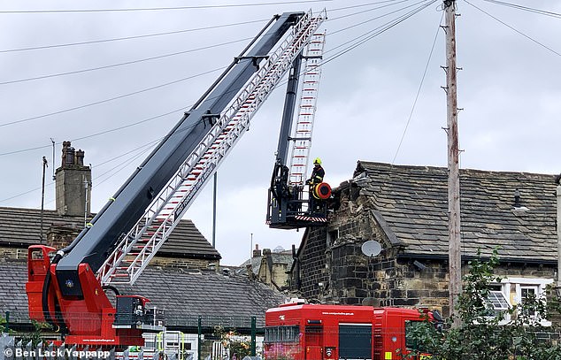 Pictured are fire officers inspecting the damage to the two-storey property in Bradford