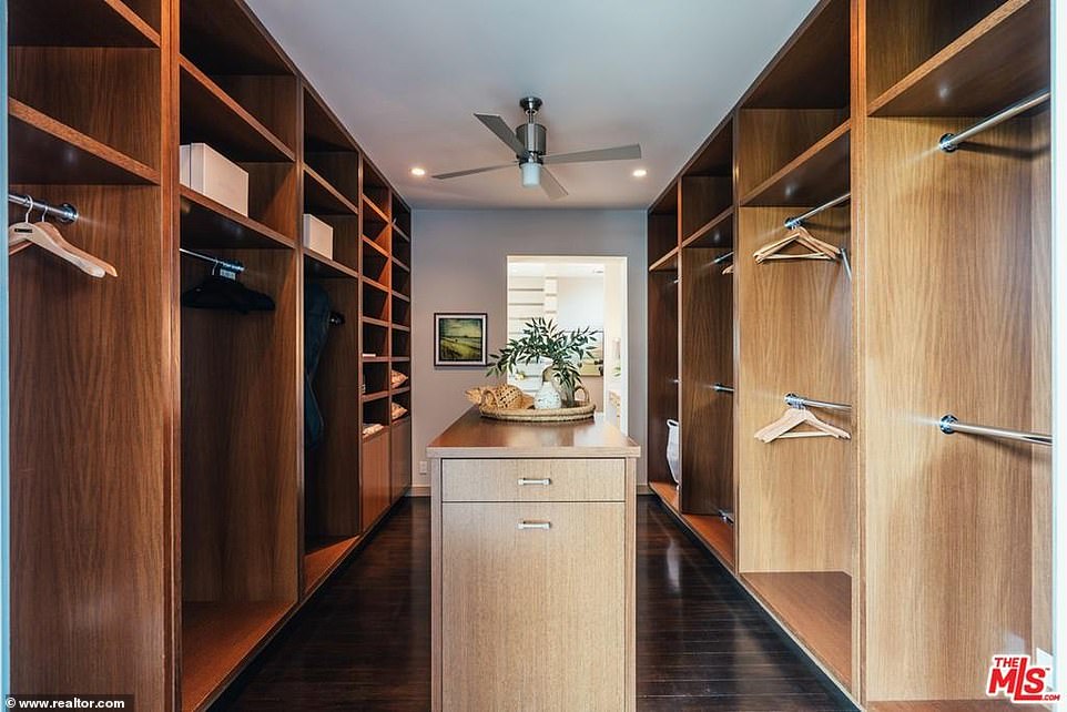 Clothes minded: A dark wood walk-in closet is every girl's dream with dark floors and an island perfect for storing costume jewelry and fancy purses