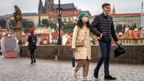 Visitors cross the medieval Charles Bridge in Prague as the Czech Republic experiences record growth after lowering its numbers.