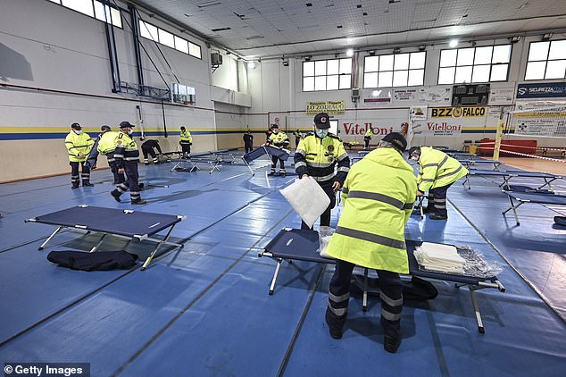Civil protection staff prepares field hospital beds for potential COVID-19 patients in Tinin, Italy on Thursday.