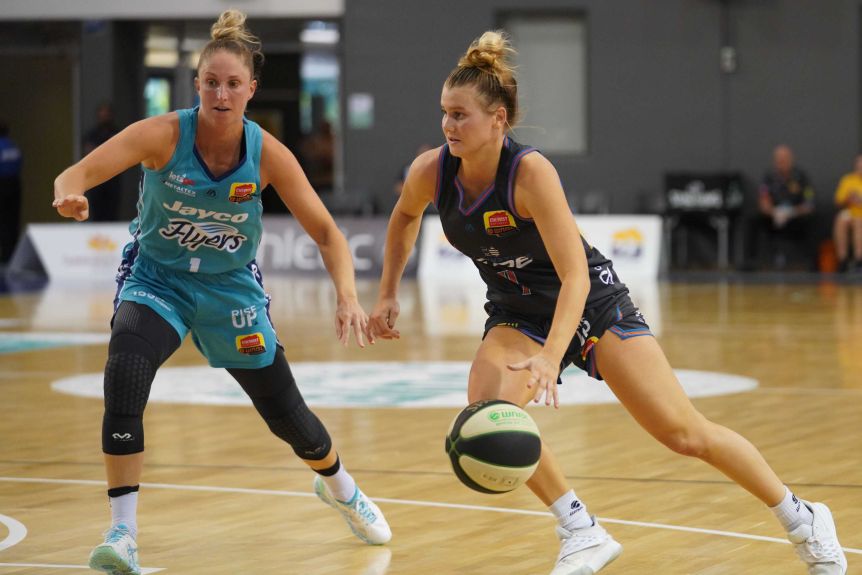 Tasnusville Fire WNBL player dribbles the ball with his left hand against the Southside Flyers.