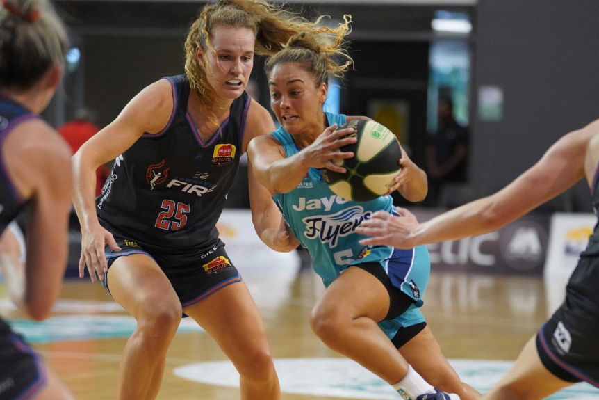 A South Tside Flyers WNBL player runs to the basket, being rescued by the Townsville Fire.