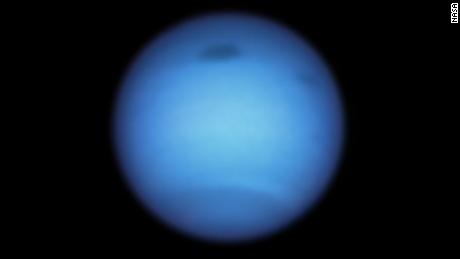 This Hubble Space Telescope snapshot of Neptune shows a large dark storm (top center) and the emergence of a small dark space near (top right). 