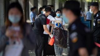 Students have their bags disinfected before entering Wuhan University, on the first day of classes in Wuhan on June 8, 2020