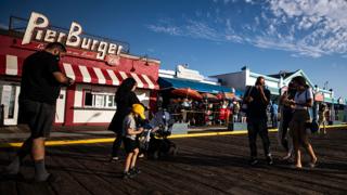 Visitors walk in Santa Monica, California, as businesses start to reopen