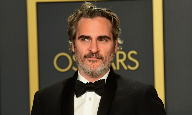 Joaquin Phoenix smiling slightly, looking to the side