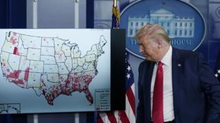 President Donald Trump with a map of US states affected by coronavirus at a White House briefing, 23 July 2020