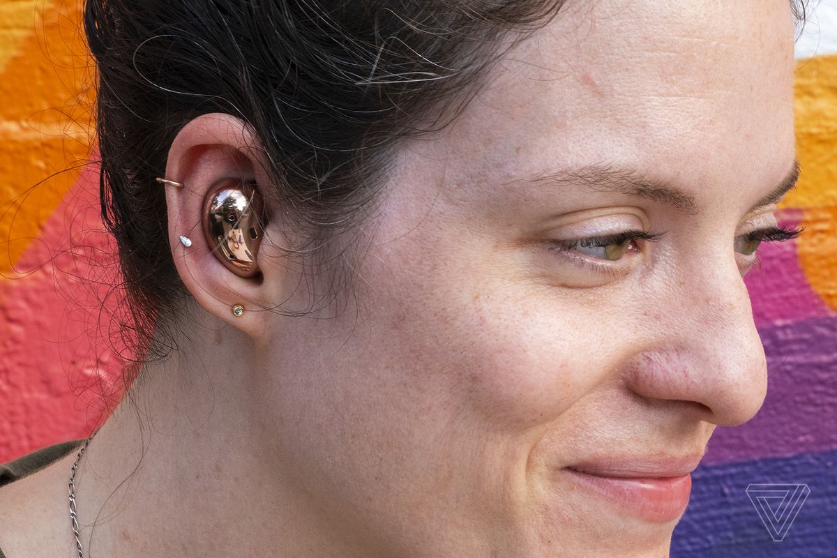 A photo of Samsung’s Galaxy Buds Live in someone’s ear.