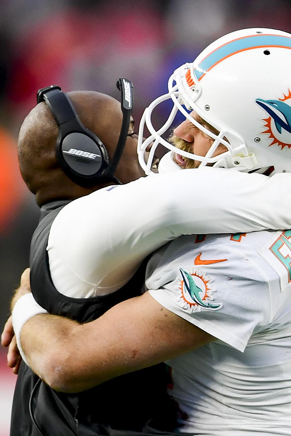 Miami Dolphins' Ryan Fitzpatrick embraces head coach Brian Flores. 