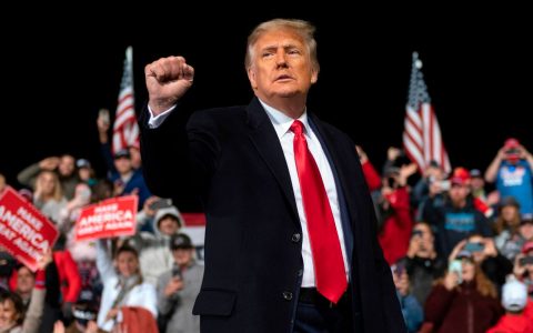US President Donald Trump holds up his fist as he leaves the stage at the end of a rally to support Republican Senate candidates at Valdosta Regional Airport in Valdosta, Georgia on December 5, 2020.