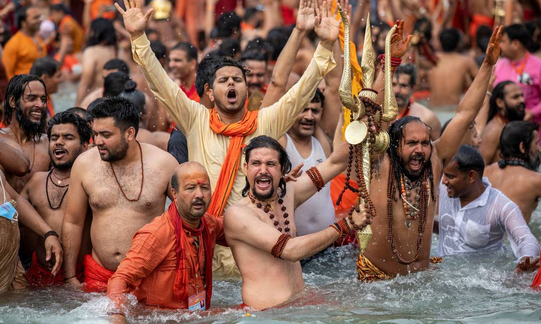 Hindus bathe in a river without social distance and protective equipment