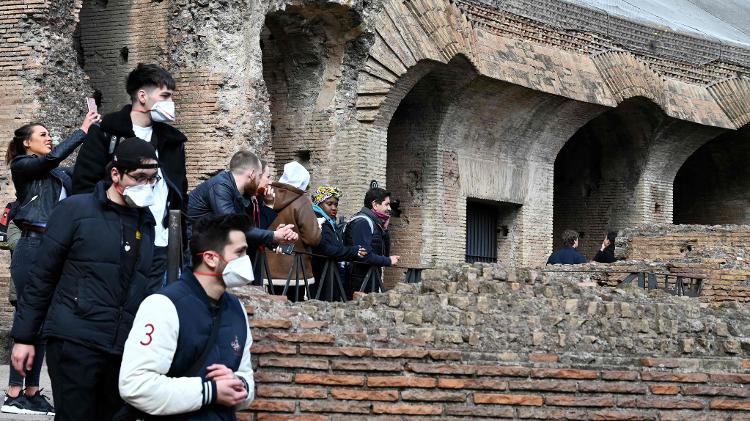 06.mar.2020 - Tourists wear masks during a visit to the Colosseum - Tiziana Fabi / AFP - Tiziana Fabi / AFP