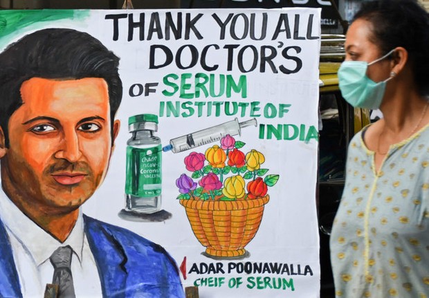 A woman with a portrait of Adar Poonawala, CEO of Serum Institute of India, undergoes a painting welcoming the Kovid-19 vaccination program (Photo: Ashish Vaishnav / Sopa Image / via Getty Images by Lightrocket)
