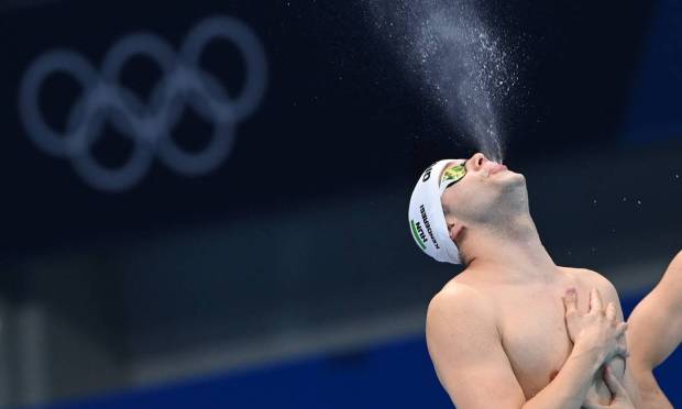 Hungarian swimmer Tamas Kenderesi spitting water before the men's 200m butterfly swim semifinal Photo: ATTILA KISBENEDEK / AFP