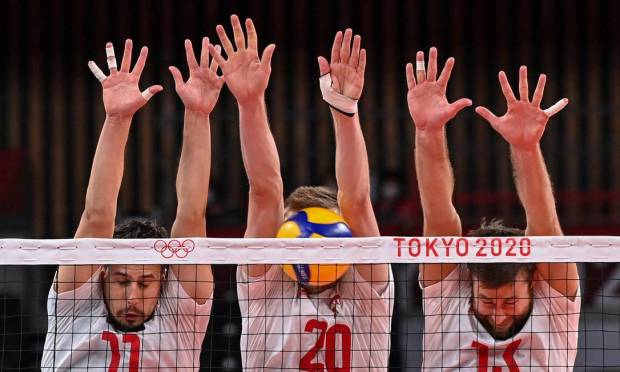 The Polish blockade created by Fabian Drizzyga, Mateusz Bieniec and Michal Kubiak against the attack of the Venezuelan team on men's volleyball Photo: Angela Weiss / AFP