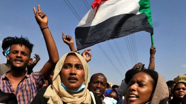 Protesters wave the Sudanese flag in the capital Khartoum to condemn the military's arrest on 25 October 2021.