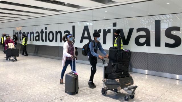 People with suitcases at Heathrow Airport arrivals terminal