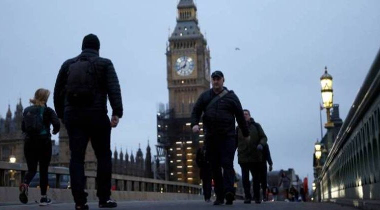 Pedestres caminham sobre a ponte de Westminster em meio à pandemia de Covid-19