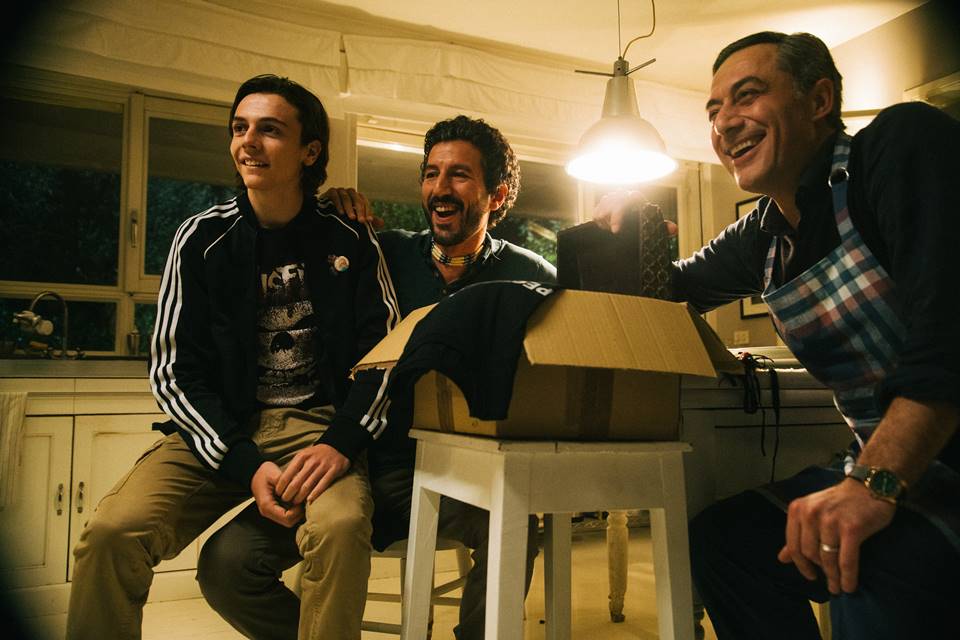 smiling three men sitting around a table