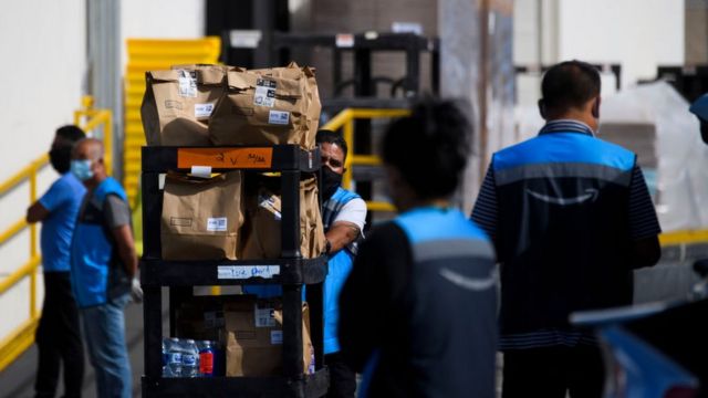 Amazon employees carrying boxes