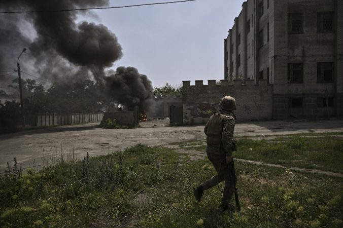 A Ukrainian soldier walks in front of a burning vehicle during an artillery duel between Ukrainian and Russian troops in the city of Lisichansk in the Donbass region of eastern Ukraine.