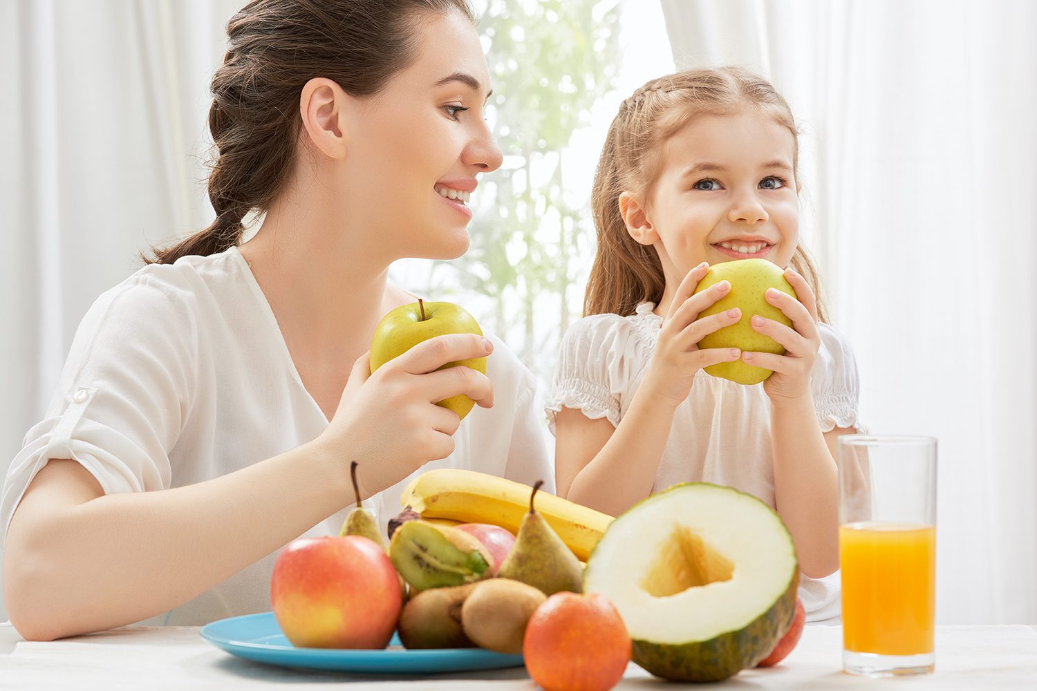 mother and daughter eat fruit