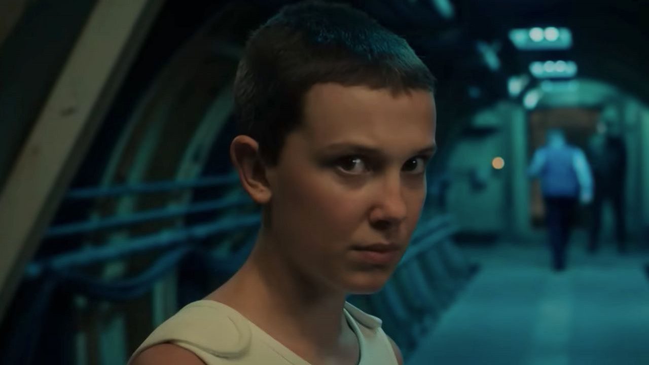 Millie Bobby Brown with a serious expression in a scene from Stranger Things